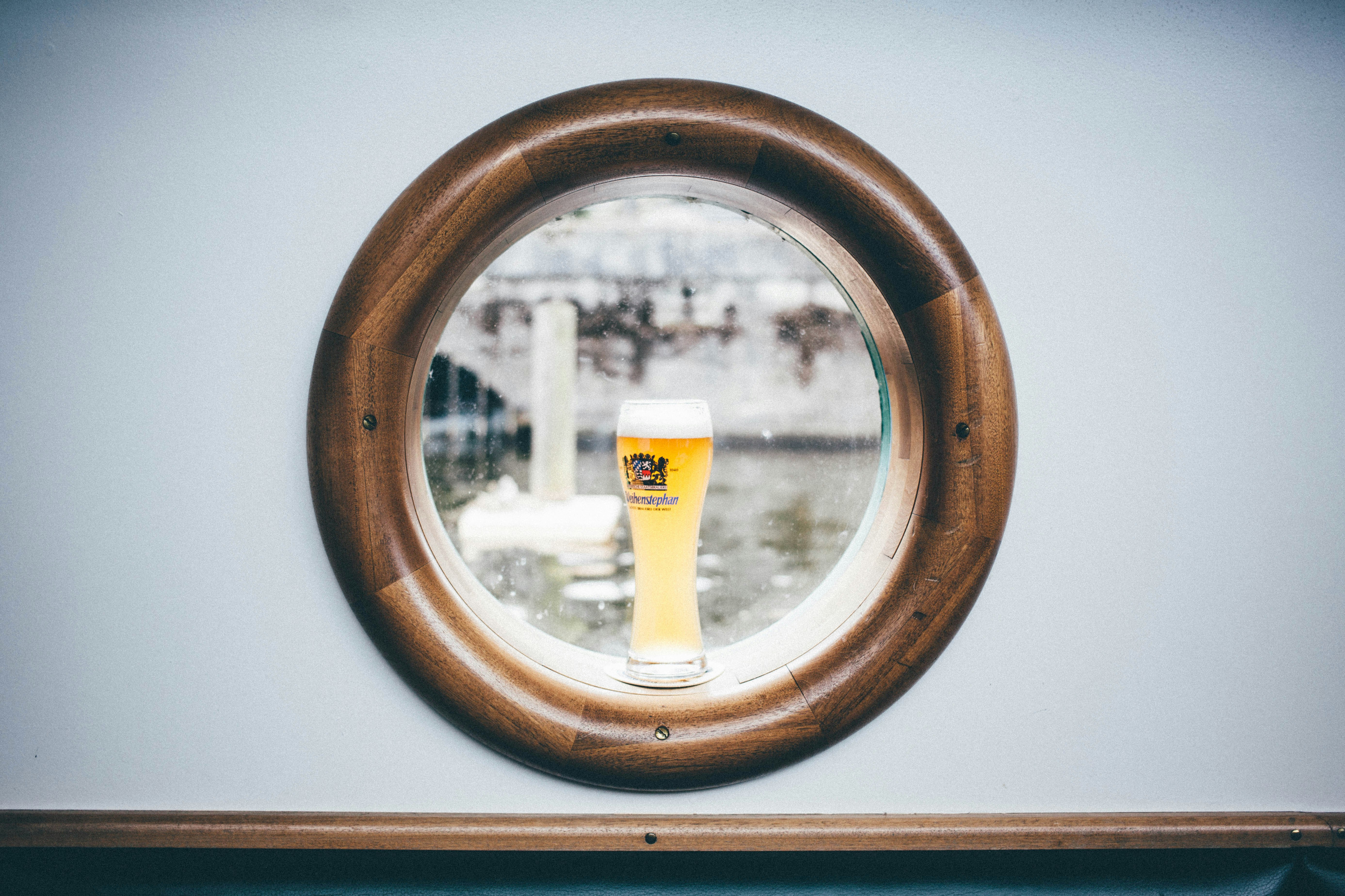 clear glass filled with yellow liquid on window